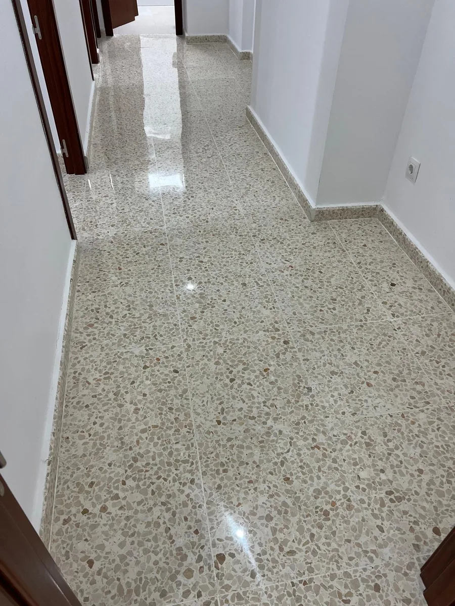 Pasillo de terrazo claro con acabado brillante